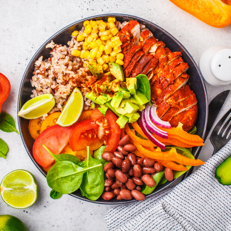Burrito bowl with a variety of toppings such as veggies, rice, and protein