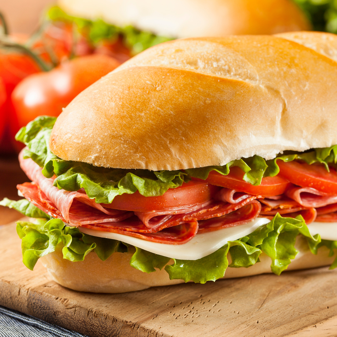 Sub sandwich with a variety of toppings such as lettuce, ham, tomatoes, and cheese